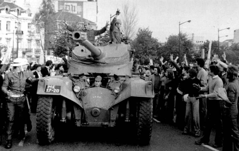 FILE - In this April 25 1974 file picture, people cheer soldiers in a tank driving through downtown Lisbon during a military coup.